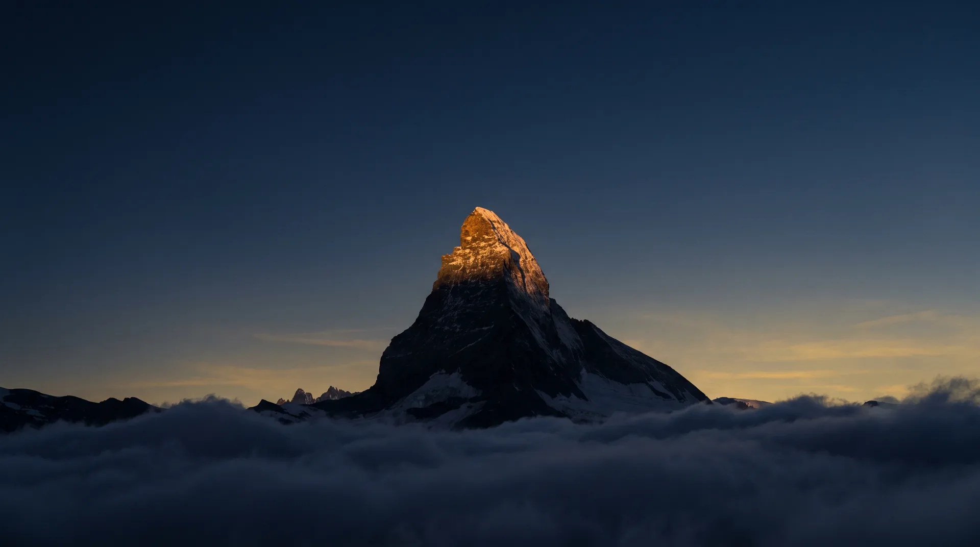 Das Matterhorn im ersten Licht über einem Wolkenmeer